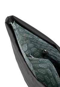 Černá taška s texturovaným povrchem, s vzorovaným zeleným interiérem, zipovým uzávěrem a vnitřní kapsou.