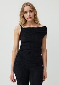 Zwarte off-shoulder top gemaakt van textiel met structuur, met een aansluitend ontwerp en dunne bandjes. De stof vertoont een gekreukt patroon.