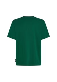 Grøn bomulds t-shirt med korte ærmer, rund halsudskæring og lige snit. Har et lille mærke på venstre side tæt på sømmen.