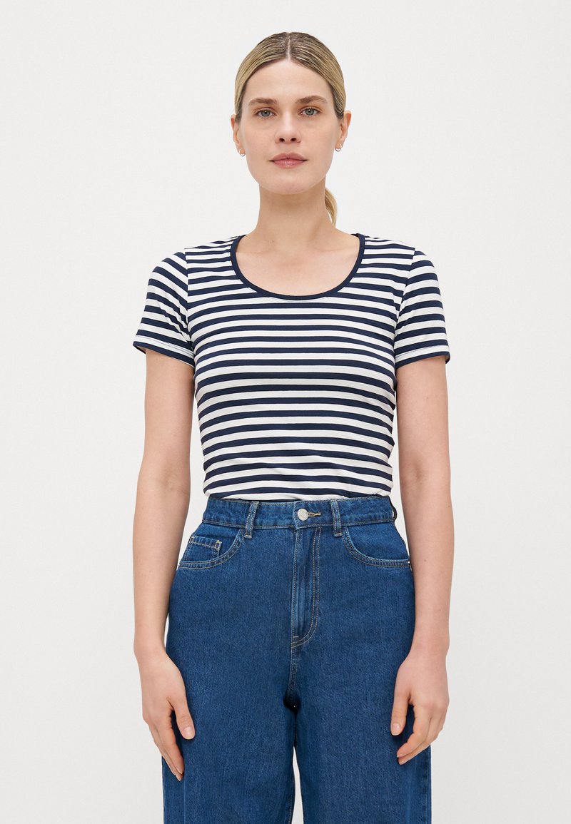 Striped t-shirt in navy and white, featuring a rounded neckline and short sleeves, paired with high-waisted blue denim jeans.