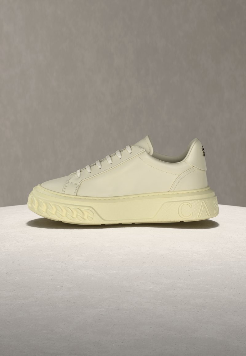 Εκρού χαμηλό sneaker με παχύ υφασμάτινο πάτο, στρογγυλεμένη μύτη, δέσιμο με κορδόνια και ανάγλυφες λεπτομέρειες στη φτέρνα και στην πλευρά.