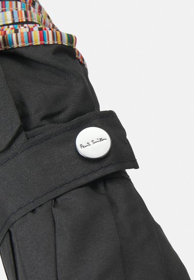 Crni kaput od tkanine s naboranim detaljem na ovratniku, s multikolorom prugastom unutrašnjošću. Srebrni gumb s ugraviranim natpisom "Paul Smith".