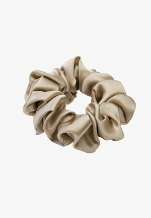 Beige satijnen scrunchie met zachte, geplooide stof die een cirkelvormige haaraccessoire vormt tegen een witte achtergrond.