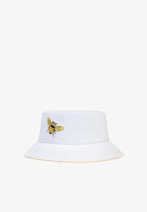 Cappello a secchiello bianco con ricamo di un'ape gialla sul lato. La visiera è ampia, con un accento giallo lungo il bordo. Realizzato in cotone.