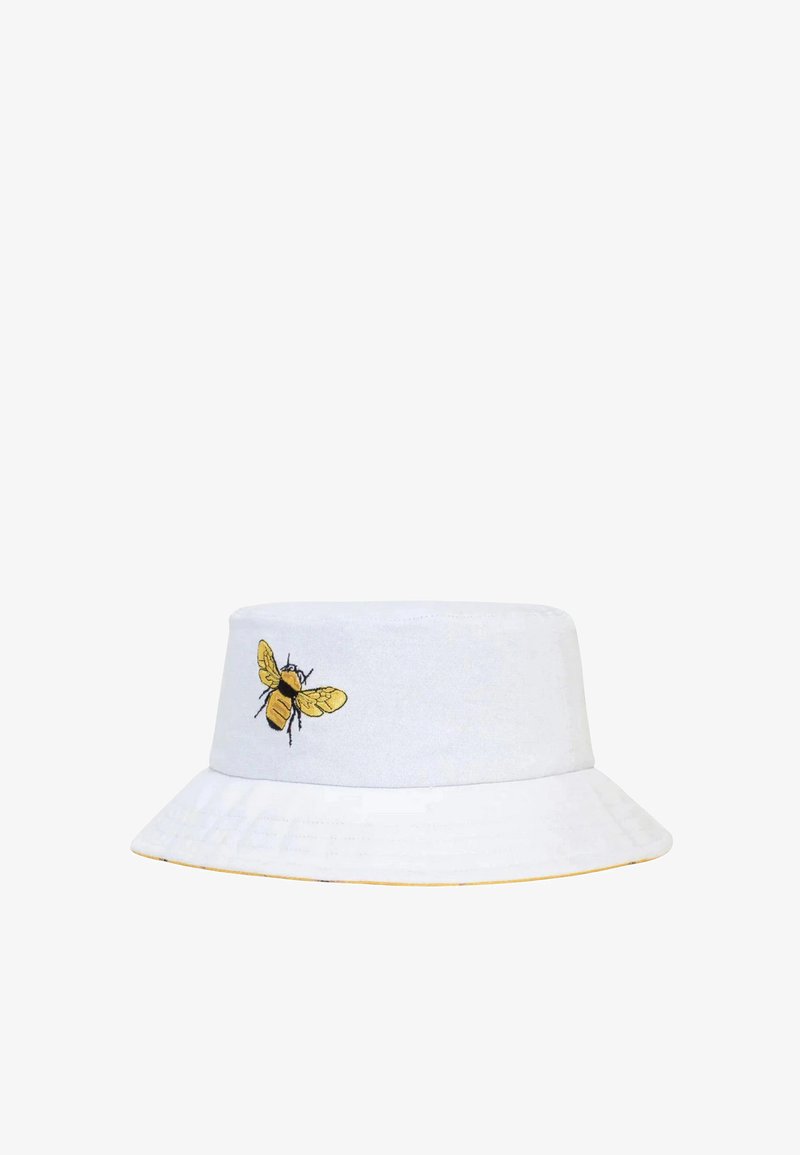 Cappello a secchiello bianco con ricamo di un'ape gialla sul lato. La visiera è ampia, con un accento giallo lungo il bordo. Realizzato in cotone.