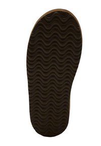 Suela de zapato de goma negra con un patrón de tracción ondulado y bordes redondeados, que presenta un borde exterior marrón para mayor durabilidad.
