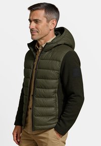 Opgevulde olijfgroene gilet met een capuchon, voorzien van een donkergroene wolmix op de mouwen en een ritsluiting. Textuur en geïsoleerd ontwerp.