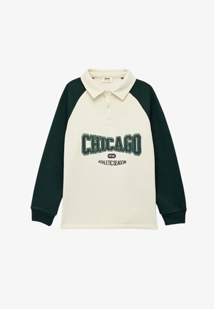 Langarm-Polohemd mit cremefarbenem Körper und dunkelgrünen Raglanärmeln. Mit aufgesticktem Schriftzug "CHICAGO 1938 ATHLETIC SEASON".