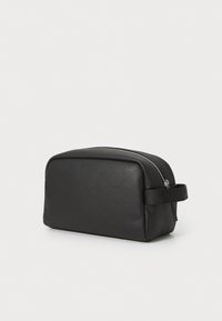 Black leather toiletries bag with a textured finish, rectangular shape, zip closure on top, and a side handle for easy carrying.