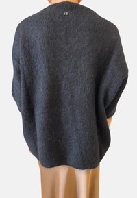 Maglione oversized grigio carbone con una finitura morbida e testurizzata. Presenta un colletto rotondo e un dettaglio del logo sulla schiena. Orlo arrotondato.
