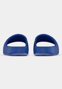 Modré topánky na nazúvanie s otvoreným pätovým dielom a zaobleným tvarom. Hladká štruktúra, ľahký dizajn a plochá podrážka. Žiadne viditeľné kovanie ani vzory.