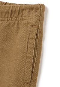 Bruine corduroy broek met een gestructureerde stof, taps toelopend ontwerp en zijzak met gestikte details.