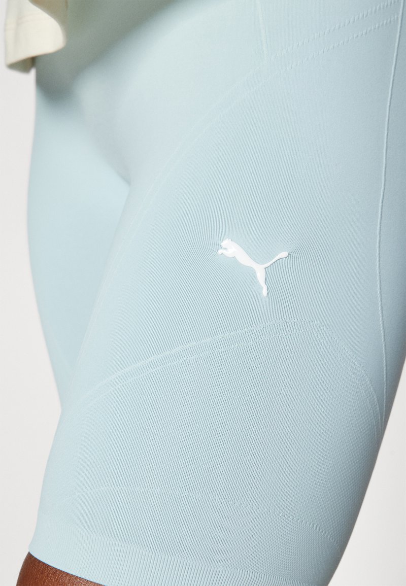 Shorts atletici azzurro chiaro realizzati in tessuto elasticizzato, con un motivo testurizzato e un logo Puma bianco sulla coscia.