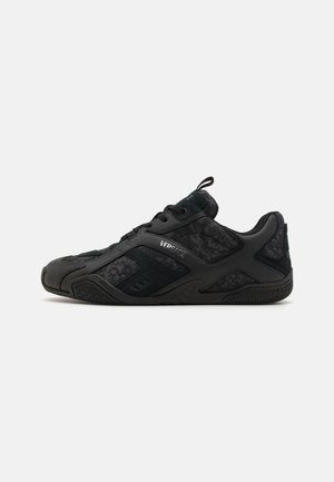 Black sneaker with a mix of textured fabric and smooth synthetic material, featuring a lace-up design and subtle branding details.