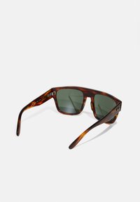 Ochelari de soare din material tartan, cu lentile verzi închise, formă pătrată și brațe elegante cu accente de metal argintiu.