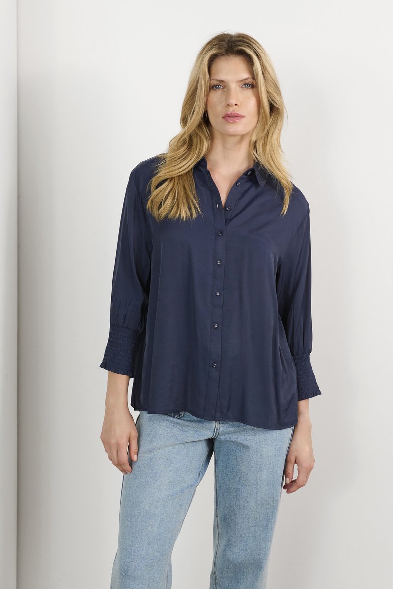 Tumesinine, kraepeenidega nööbipaelshirts pikade, r gathered varrukatega ja vabalt istuv. Sile kangas kerge läikega, koos helesiniste teksadega.
