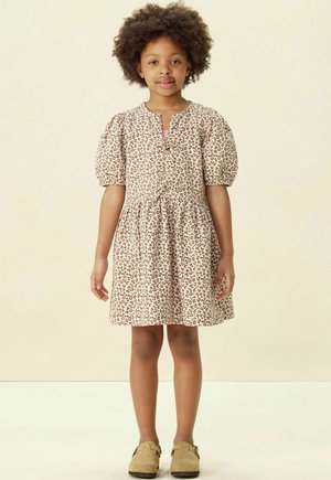 Leopardenmusterkleid mit Puffärmeln, rundem Ausschnitt und geraffter Taille. Weicher Stoff in hellem Beige mit braunen Punkten.