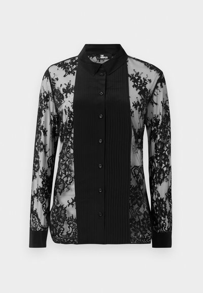 Svart langermet skjorte med gjennomsiktig blonde-design, en teksturert frontpanel med folder og knappelukking.
