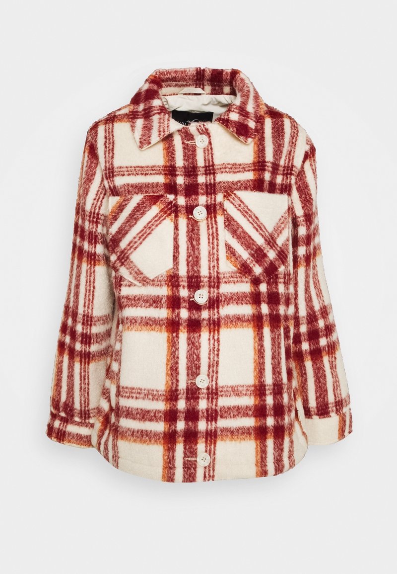 Flannel shirt jacket with red and orange plaid pattern on a cream background. Features a collar, buttons, and chest pocket. Soft texture.
