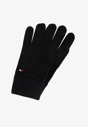 Gants en tricot noir avec des poignets côtelés et un petit logo rectangulaire rouge, blanc et bleu au poignet.