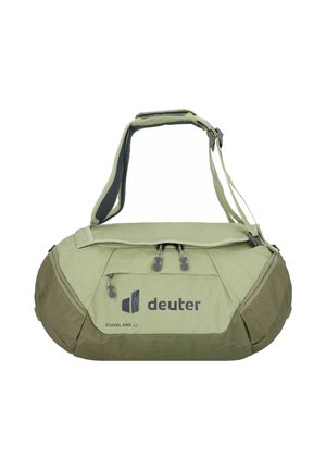Bolsa de lona verde con asas laterales dobles, correa de hombro acolchada, cierre superior con cremallera y exhibición de logotipo; fabricada con tejido duradero y acentos texturizados.