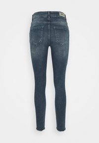 Jeans ajustados de mezclilla azul oscuro, con un dobladillo deshilachado, dos bolsillos traseros y un ligero desvanecimiento. La etiqueta dice "ONLY" en la cintura.