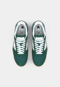 Pantofi sport verzi cu partea superioară din suede, dungi albe și sistem de șireturi alb. Încălțăminte cu talpă texturată din gumă și detalii cu logo pe limbă.