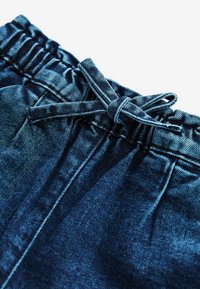 Shorts in denim blu scuro con elastico in vita e dettaglio con coulisse. Il tessuto ha una texture liscia e pattern di scoloritura delicati.