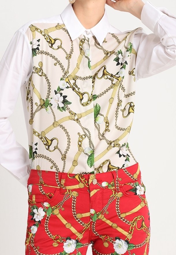 Skjorta med långa ärmar och vit krage, med ett kedje- och blommönster på framsidan. Röda byxor med ett liknande mönster, guldaccentuerade.