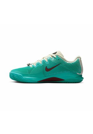 Nike tennisschoenen hebben een turquoise gestructureerde bovenkant met witte accenten. De zool is ontworpen voor grip, met een opvallende rode streep aan de zijkant.
