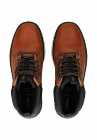 Chaussures de randonnée en cuir marron avec des accents et des lacets noirs. Elles présentent un col rembourré, une semelle en caoutchouc et une surface texturée. Marque Geox visible.