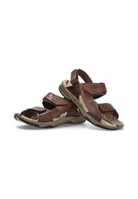 Sandalias de cuero marrón con correas de Velcro, diseño perforado y suela de goma beige. Plantilla texturizada y acentos contrastantes llamativos.