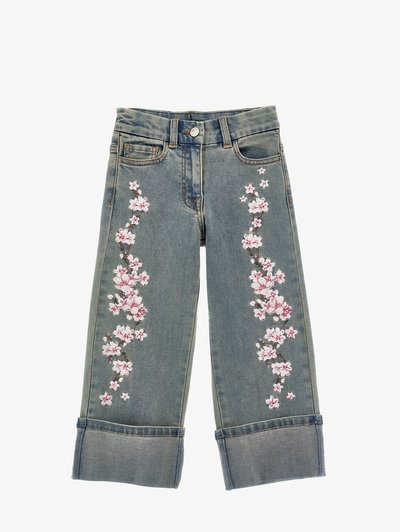 Lyseblå denim jeans med broderte rosa kirsebærblomster langs sidene og oppbrettede cuffs i sømmen.