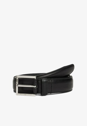 Ceinture en cuir noir avec une boucle rectangulaire en argent gravée du nom de la marque, enroulée sur un fond blanc.