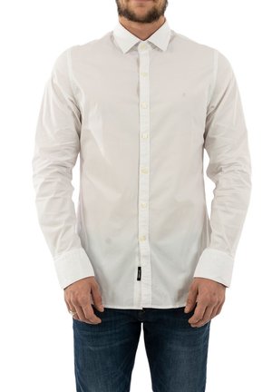 Camisa blanca de manga larga con botones y un cuello clásico, con una textura de algodón suave y un pequeño logo en el pecho.