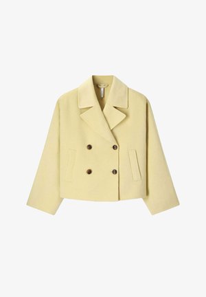Manteau court jaune en laine cropped à double boutonnage, avec de larges revers, deux poches latérales et quatre boutons marron.