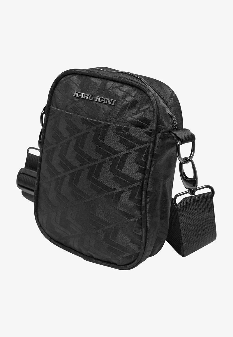 Black accessory bag featuring a textured geometric pattern, zip closure, front pocket, and adjustable strap with metal hardware accents.