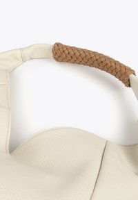 Un sac en cuir blanc avec une poignée tressée couleur tan. La texture est granuleuse, avec une finition lisse sur le corps et des coutures d'accent.
