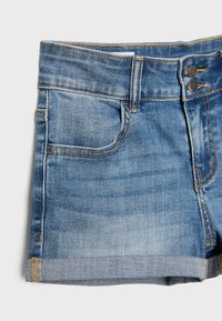 Shorts en denim bleu avec ourlets retroussés, poches avant, passants pour ceinture et deux boutons en métal sur la ceinture.