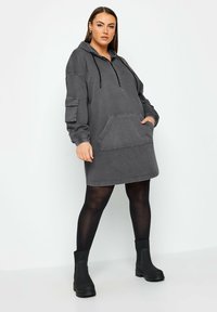 Grå denim hoodie klänning med halv dragkedja, stor ficka fram och sidoficka; har elastiska ärmslut och avslappnad passform.