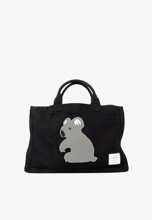 Sort tote-taske med korte håndtag og et stort gråt koala-patch på forsiden samt en lille hvid rektangulær label i nederste hjørne.