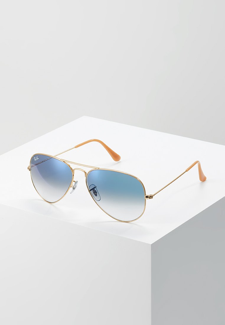 Ochelari de soare aviator din metal aurit, cu lentile gradiene albastre și vârfuri din cauciuc portocalii, având pernuțe de nas ajustabile.