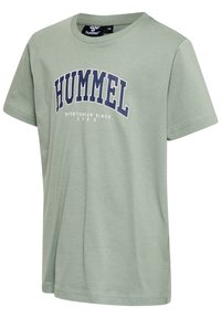 Ljusgrön bomull T-shirt med rund halsringning, korta ärmar, och en marinblå tryckt "HUMMEL SPORTSWEAR SINCE 1923" grafik.