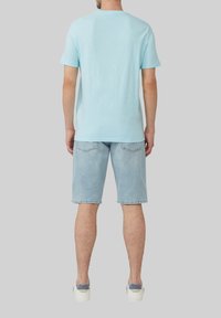 Jasnoniebieska, krótko rękawowa koszulka z okrągłym dekoltem, zestawiona z jasnoniebieskimi szortami dżinsowymi i białymi trampkami. Prosty styl, luźny krój.
