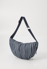 Borsa stile hobo in tessuto blu navy con motivo a strisce zebra, texture morbida, tracolla regolabile e chiusura con zip su un lato.