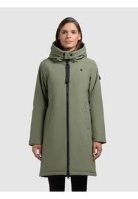 Cappotto verde imbottito con colletto alto, grande cappuccio, zip frontale e tasche laterali. Presenta il logo del brand sul petto e sul polso.