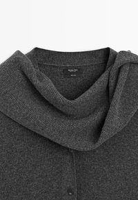 Gray wool cardigan featuring a draped cowl neck, ribbed texture, and five black buttons along the front placket. Label visible inside.