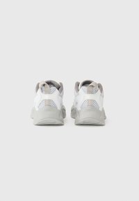 White athletic shoes featuring mesh panels, a round toe, and a gray outsole. Includes a pull tab on the heel for easy wear.