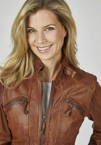 Braune Leder-Motorradjacke mit Reißverschluss vorne, mehreren Reißverschlusstaschen und Druckknopfdetails. Glatte Textur und taillierte Passform.