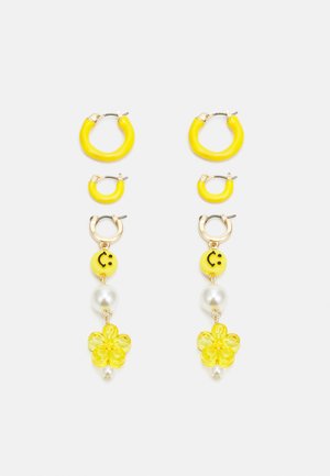 Brincos em forma de aro amarelos com textura suave, apresentando aros menores, contas sorridentes, detalhes em pérola e charms florais.